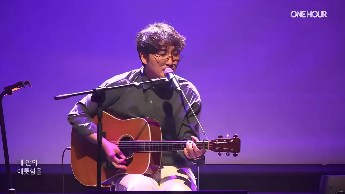 Kwon Nam-joo interpreta 'Uri-ege' con su guitarra en el escenario de ONE HOUR